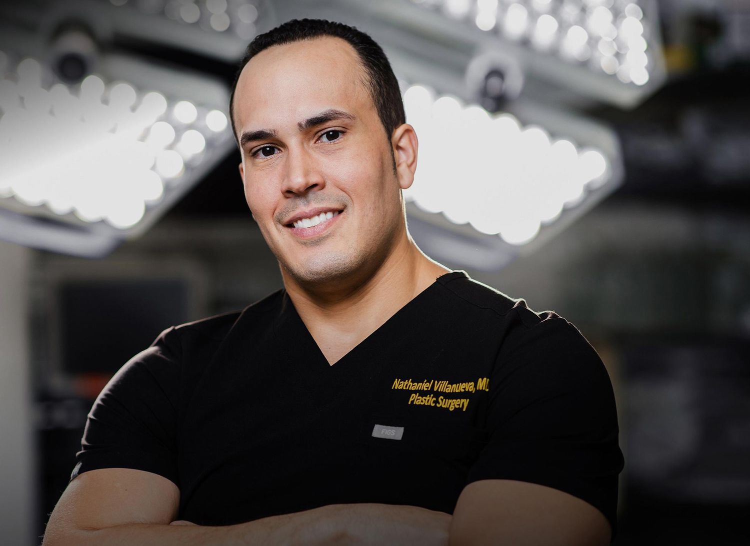 Male plastic surgeon smiling in surgical attire.