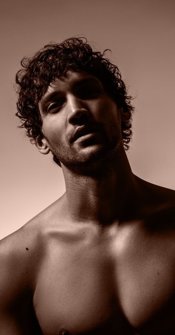 Portrait of a man with curly hair, sepia tone.